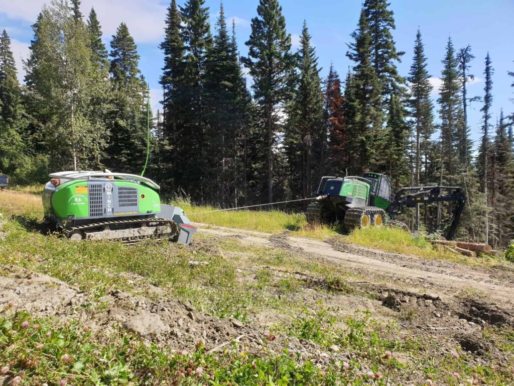 T-WINCH 10.2 tethered to a John Deere loader in a forest