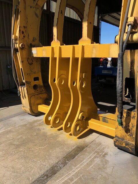 Yellow logging forks custom fabricated for a CAT wheel loader
