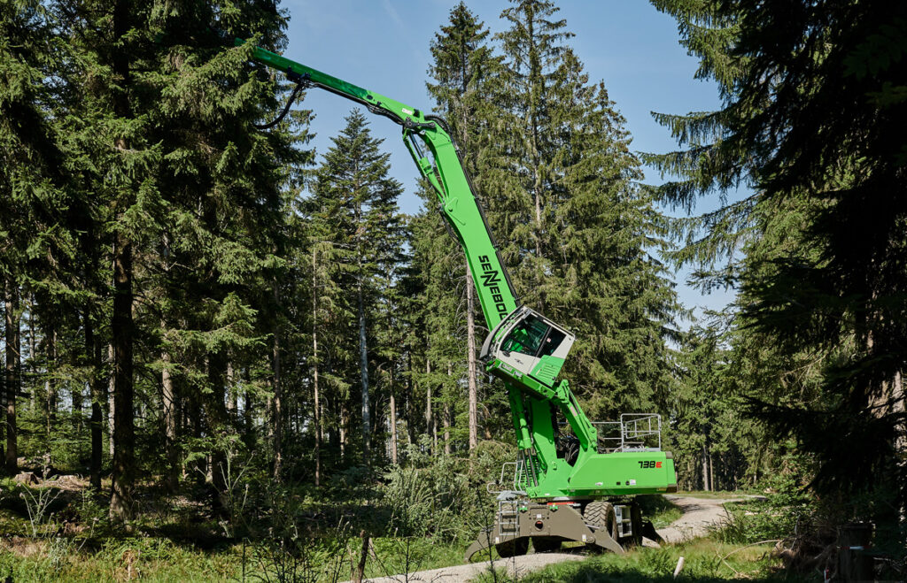 Sennebogen 738 E-Series machine cutting down a tree on a job site.
